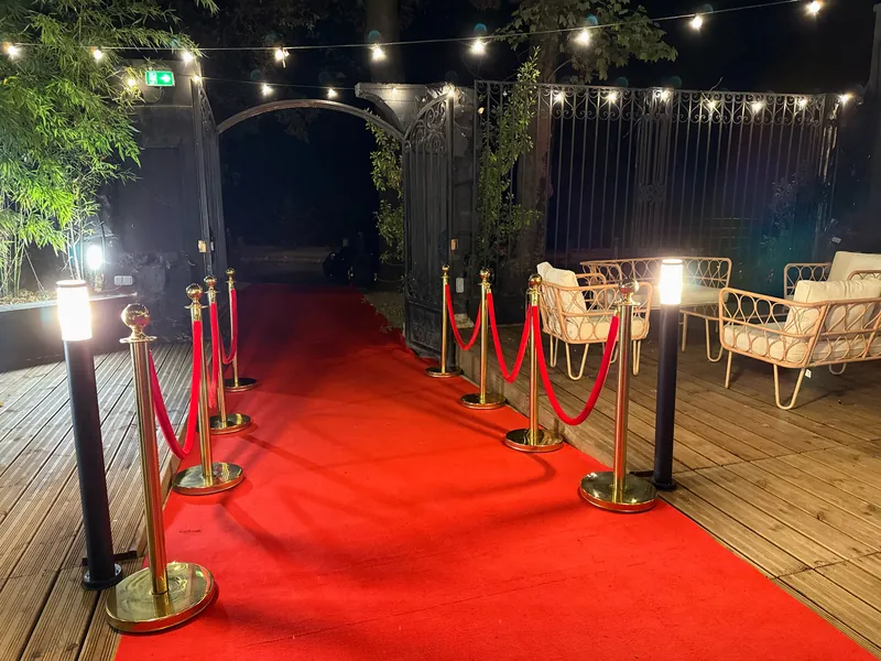 Tapis rouge, cordons dorés et fauteuils à l'entrée de la terrasse de Maya
